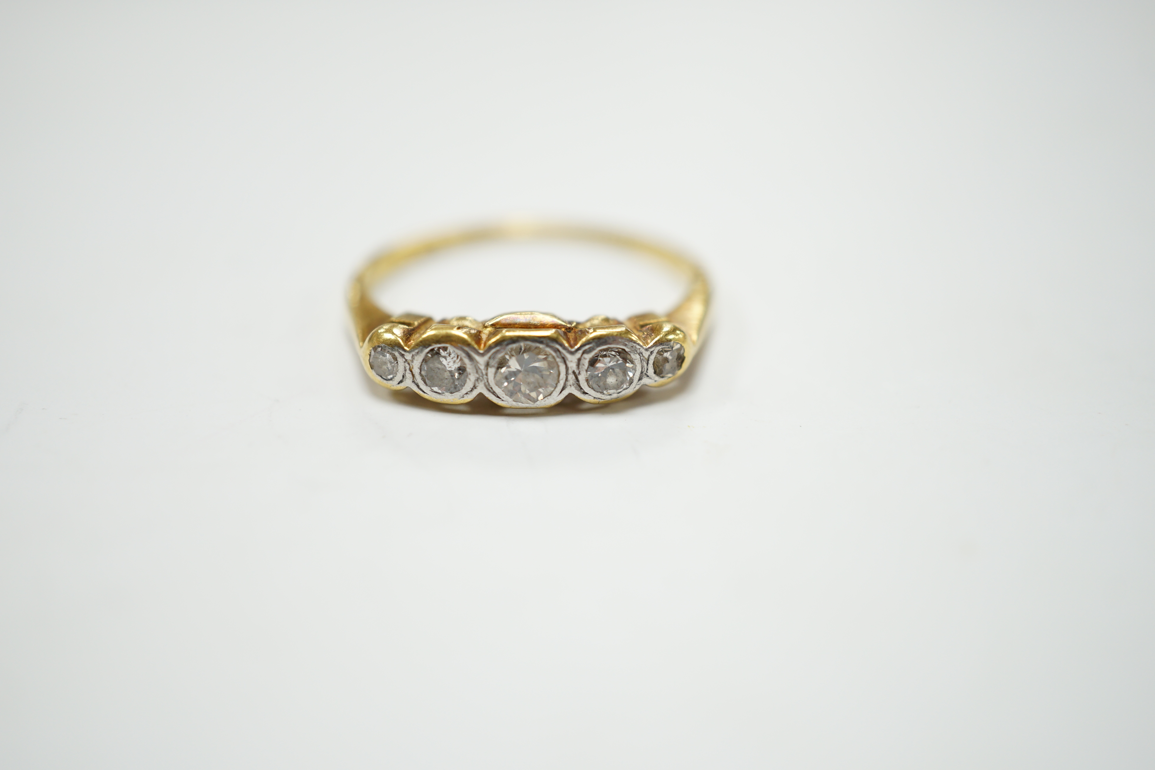 An 18ct, plat and graduated collet set five stone diamond half hoop ring, size P, gross weight 3.1 grams.